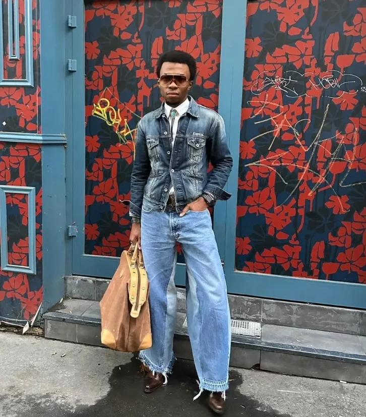 Homme qui pose devant une boutique avec une tenue stylée et vintage