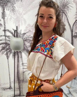 Femme qui pose avec une tenue dans une friperie